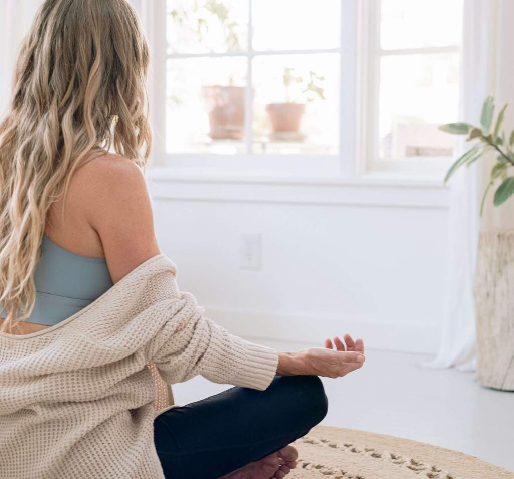 A woman in a yoga pose, hands on knees, finding solace. A guide to overcoming a slump.


